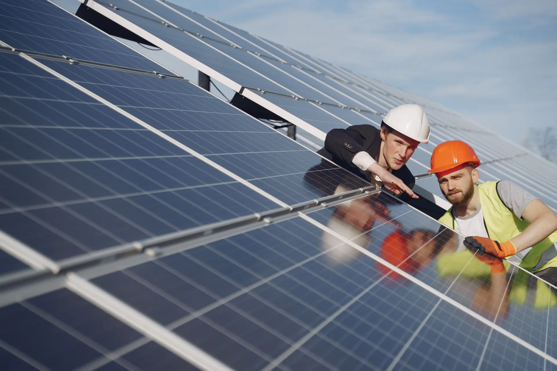 Zwei Monteure prüfen Photovoltaikmodule auf dem Dach