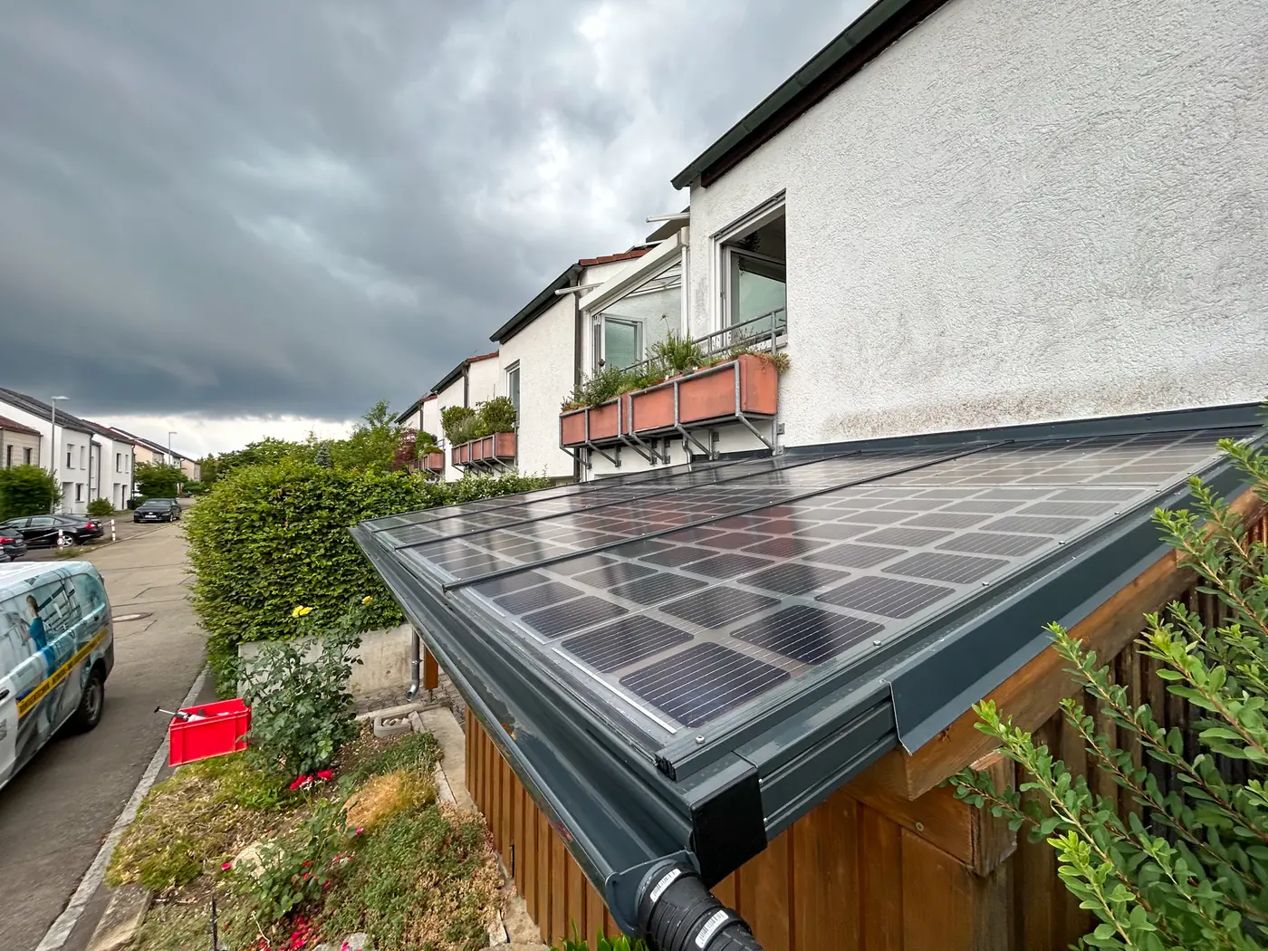 Holz-Solarcarport mit Glas-Glas-Modulen neben einer Einfahrt