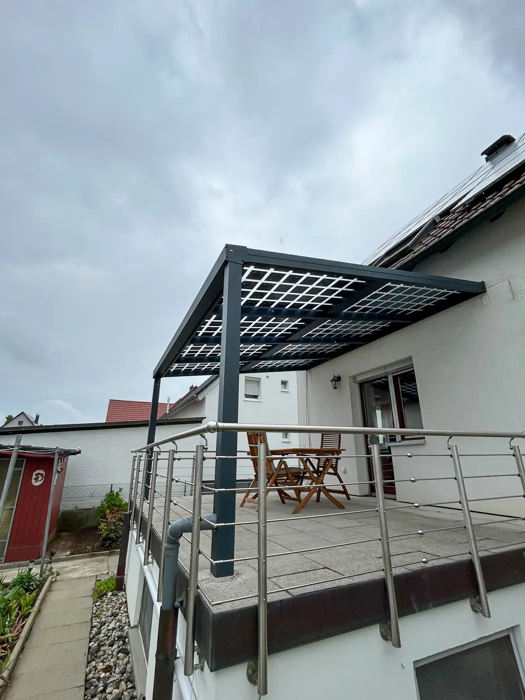 Solarterrasse mit Glas-Glas-Modulen über einem Balkon mit Edelstahlgeländer