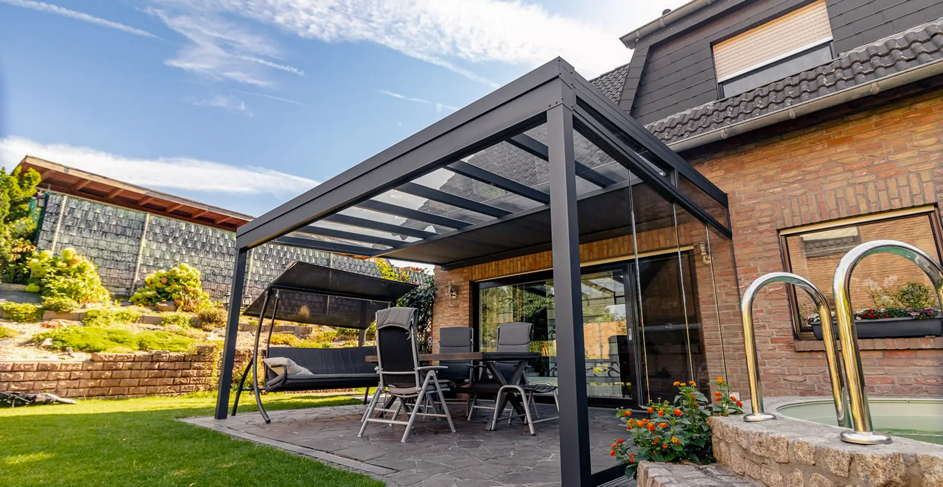 Terrassenüberdachung mit Glasdach und Glasschiebewänden am Pool