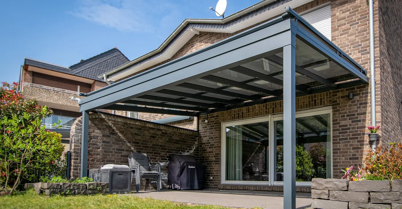 Glasdach-Terrassenüberdachung vor einem Klinkerhaus